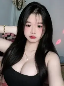 Trong phòng ngủ hồng nhẹ, áo đen khoét cổ tôn vùng ngực đầy nữ tính