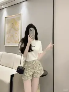Căn phòng kem dịu có cô gái áo trắng váy hoa che mặt trước gương lớn