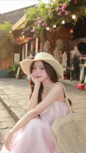 Trên con hẻm nắng ấm, cô gái đội nón cói, váy hồng mềm và mắt cười hiền