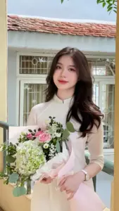 Trước hiên nhà sáng màu, người đẹp Việt ôm bó hoa, váy trắng hồng nhìn dịu dàng