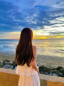 Bãi biển hoàng hôn nàng thơ giấu mặt nổi bật với mái tóc dài và váy cam