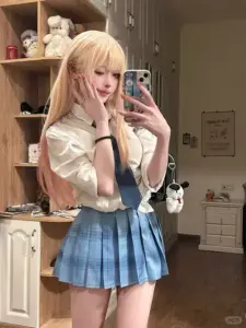 Gương selfie bắt trọn cô gái tóc vàng mặc sơ mi be, váy xanh xếp ly trẻ trung