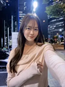 Dưới ánh đèn phố đêm, cô nàng tóc dài chụp selfie, áo hồng nhạt tôn da sáng