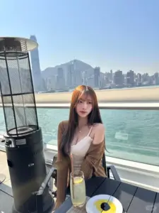 Trên du thuyền nắng nhẹ, cô gái tóc nâu mặc áo trắng ngồi trước đường chân trời