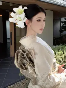 Bên lối vườn yên tĩnh, cô gái mặc kimono trắng cài hoa lớn, nghiêng mặt dịu dàng