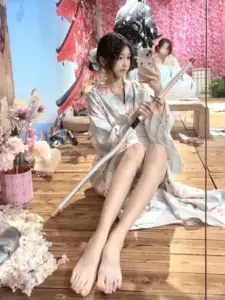 Trong góc trang trí hoa, cô nàng ngồi thư thái với áo lụa sáng màu và nụ cười nhẹ