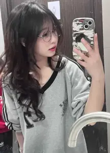 Tấm chụp gương trước bàn trang điểm bắt tóc xoăn, áo phối màu và dáng nghiêng cuốn