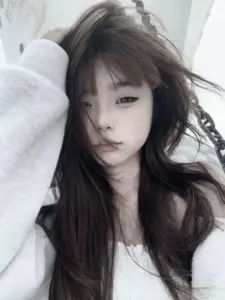 Cận mặt bên rèm trắng giữ visual trong trẻo, mái tóc dài rơi mềm trên áo len