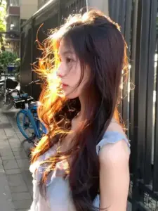 Ánh nắng hắt qua cửa làm mái tóc xoăn nâu của cô gái thêm mềm mại