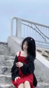 Bậc thang ven biển làm gái đẹp TikTok nổi bật với áo đen và cốc đỏ nhỏ