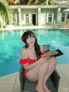 Bên hồ xanh biệt thự, cô nàng diện đồ bơi đỏ thư thả ngồi cười tươi