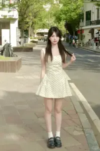 Váy xòe màu kem theo bước chân nàng trên vỉa hè, tóc đen buông rất mềm