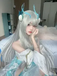 Ánh sáng phòng ngủ dịu nhẹ ôm lấy người đẹp cosplay tóc bạc, váy xanh và đôi mắt hiền