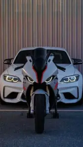 Bãi đỗ tầng cao có hình nền ô tô BMW màu trắng, thành phố phía xa phủ ánh chiều.