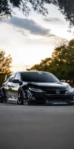 Khung đứng của ảnh khóa màn hình Civic giữ xe đỏ ở góc dưới, nền trời rộng phía trên.