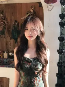 Phông gỗ ấm làm tóc xoăn và váy hoa tối màu của nàng trông nổi bật hơn