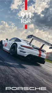 Chiếc Porsche trắng drift trên mặt đường xám, phần chữ lớn phía trước hợp làm wallpaper F1.