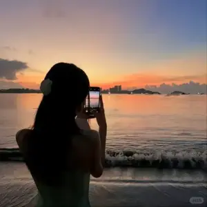 Nền trời cam tím làm bóng dáng che mặt bên biển hiện lên mềm và rất lặng