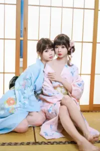 Hai cô gái hóa trang mặc kimono pastel ngồi bên cửa giấy, biểu cảm nhẹ nhàng kiểu Nhật