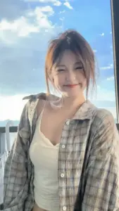 Nắng biển sau lưng làm nụ cười nàng áo caro sáng lên dưới bầu trời xanh