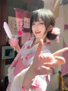 Ở gian hàng lễ hội, bóng hồng xứ hoa anh đào mặc yukata hồng đưa tay về phía máy