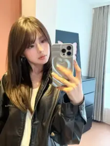 Trước gương, mỹ nhân tóc dài mặc áo khoác da chụp selfie cùng tóc nhuộm nổi bật