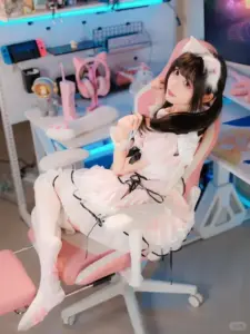 Ghế gaming hồng xanh làm nền cho nàng tóc đen ngồi thư giãn trong bộ váy maid