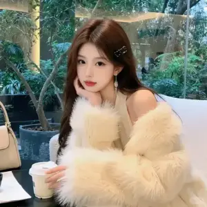 Cạnh bể kính xanh, cô gái khoác áo lông kem ngồi cầm cốc với vẻ sang nhẹ