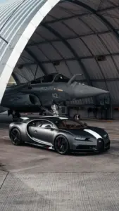 Dưới ánh neon xanh, Ferrari đỏ đứng phía sau Bugatti đen, hai dáng xe tương phản rõ rệt.