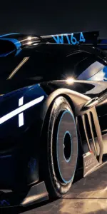 Góc chụp sát mặt đường tôn dáng hypercar rộng, đèn pha Bugatti sáng rõ giữa phố đêm.