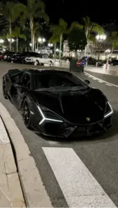 Chiếc Lamborghini Urus màu đen đứng trước tòa nhà kính, dáng SUV thể thao nhìn chắc và rất gọn.