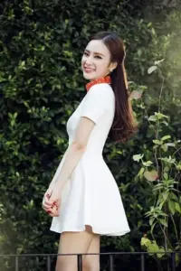 Nụ cười nghiêng vai dưới tán lá làm chiếc váy trắng xòe trông trẻ trung hơn