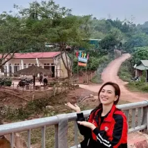 Trên ban công vùng núi, nàng thơ áo khoác đỏ đen cười tươi giữa nắng nhẹ