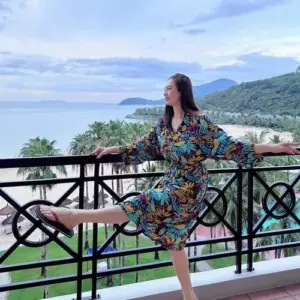 Bên ban công hướng biển, cô diện váy hoa rực rỡ tạo dáng khoáng đạt trong gió
