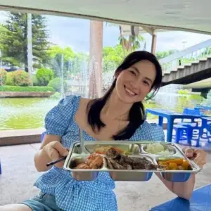Nụ cười tươi bên bàn ăn làm váy xanh caro và khay hải sản thêm gần gũi