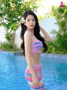 Góc hồ bơi cận cảnh làm nổi bật set len hồng xanh, tóc đen dài buông mềm