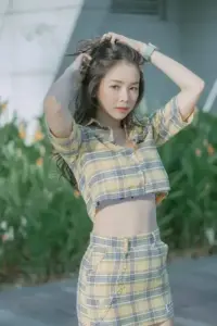 Nền lá xanh làm visual ngọt ngào thêm nổi, set caro vàng ôm dáng rất trẻ