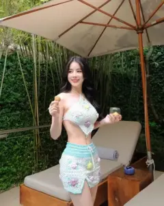 Dưới chiếc ô lớn, cô nàng diện set hoa sáng màu, nở nụ cười trong trẻo