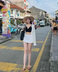 Giữa con phố du lịch, cô nàng phối áo tắm đen váy trắng và nón rộng vành