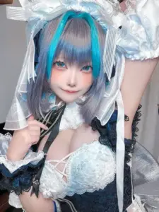 Cô gái cosplay anime mặc bikini xanh tạo dáng nghiêng nhẹ bên phông hồng ngọt ngào đầy cuốn hút