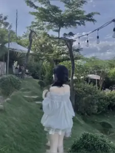 Khung vườn chiều ghi lại nàng thơ che mặt mặc váy trắng, đứng nhìn hàng cây
