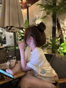 Quán nhỏ ấm sáng bên cô nàng búi tóc, áo vàng rộng và dáng ngồi thư thái