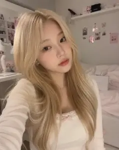 Selfie trong phòng ngủ khoe tóc vàng suôn áo len be và gương mặt trang điểm trong