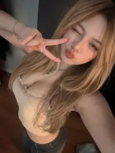 Cử chỉ giơ tay chữ V làm hotgirl tóc vàng thêm tinh nghịch dưới ánh phòng ấm