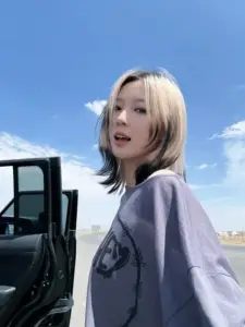 Ngoài trời xanh girl xinh tóc vàng đứng bên xe đen mặc áo khoác xám cá tính