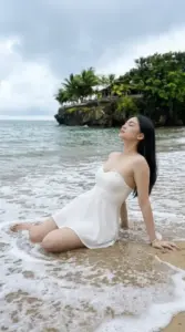 Dáng váy trắng của người mẫu Việt nổi bật khi ngồi bên sóng biển và ghềnh đá