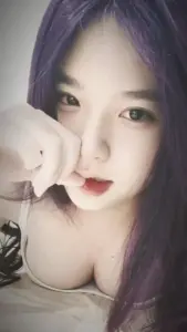 Gương mặt cận cảnh bên mèo cưng cho thấy cô nàng mắt to, tóc tím và vẻ mũm mĩm