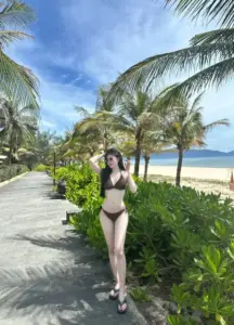 Cô nàng Việt mặc bikini đen bước trên lối đi ven biển với dáng thon cuốn hút