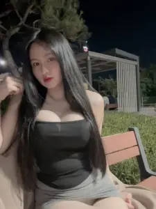 Trên ban công đêm, nàng áo đen ngồi thả dáng, khuôn ngực sáng dưới đèn mềm