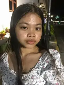 Bạn nữ váy hoa đứng ban đêm, ánh đèn sau lưng làm nét mặt trông rất thật